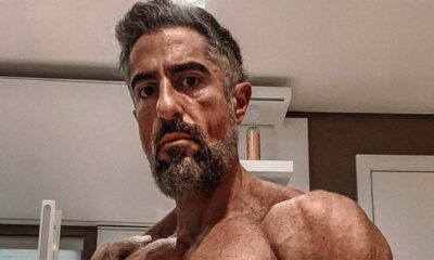 Marcos Mion sem camisa, com barba e cabelo grisalho, olhando diretamente para a câmera.