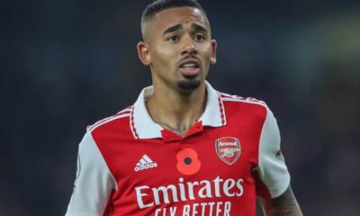 Close-up de Gabriel Jesus, jogador do Arsenal, usando camisa vermelha e branca com o símbolo da papoula.