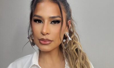 Rosto de Simone Mendes, maquiagem intensa nos olhos, lábios brilhantes, brincos prateados.