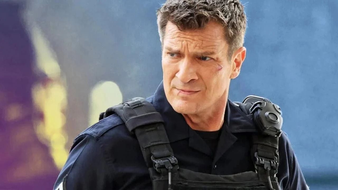 Nathan Fillion como policial John Nolan, colete tático, arranhão no rosto, olhando de lado.