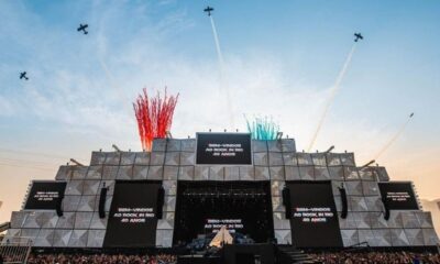 Palco do Rock in Rio com telas exibindo "40 ANOS", aviões no céu e fogos coloridos.