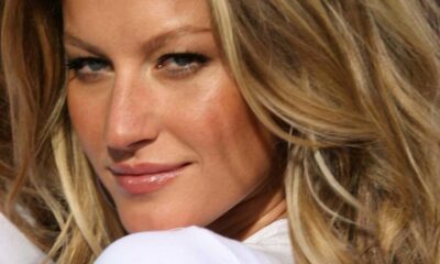 Close-up do rosto de Gisele Bündchen com olhos claros e cabelo loiro ondulado.
