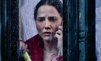 Letícia Colin (Adriana) com expressão angustiada olhando através de janela molhada pela chuva.
