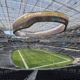 Interior do SoFi Stadium, Los Angeles, com campo, arquibancadas e telão 'SoFi Stadium', 'Hyundai', 'Samsung'.