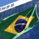 Prédio do INSS com a bandeira do Brasil e "ORDEM E PROGRESSO" tremulando.
