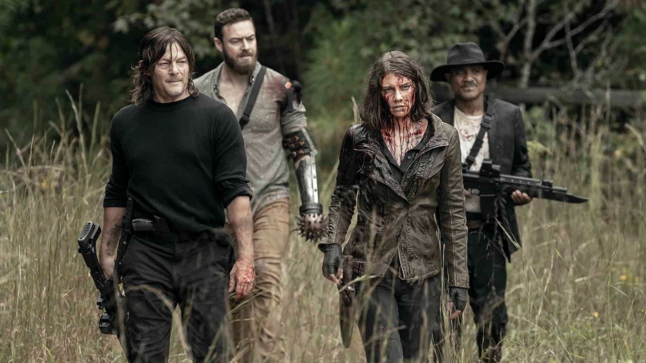Daryl Dixon, Aaron, Maggie Rhee e Gabriel Stokes caminham, Maggie ensanguentada, em floresta.