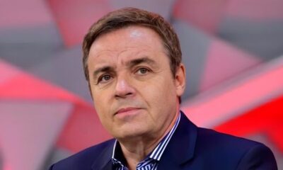 Gugu Liberato, homem de meia-idade, cabelos castanhos, terno azul e camisa listrada.
