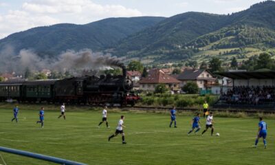 Trem histórico passa entre o campo e a arquibancada de um estádio na Eslováquia