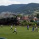 Trem histórico passa entre o campo e a arquibancada de um estádio na Eslováquia