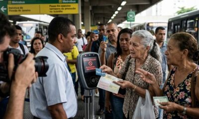 Mulher idosa tenta usar RioCard em validador de ônibus que exibe 'CARTÃO INVÁLIDO, BLOQUEADO'.