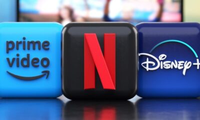 Três ícones de aplicativos: Prime Video, Netflix, Disney+. Ao fundo, TV ligada.