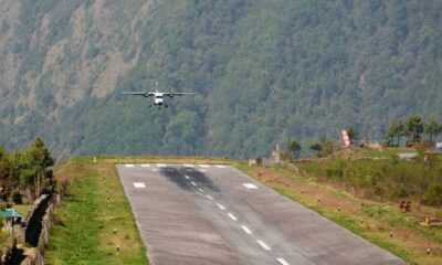 Pequeno avião bimotor em aproximação para pouso em pista curta de aeroporto na montanha.