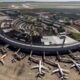 Vista aérea do terminal do Aeroporto Internacional do Galeão com múltiplos aviões e veículos de apoio em pátio.