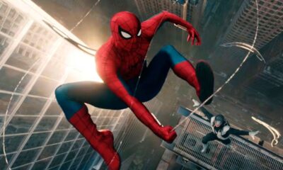 Homem-Aranha em traje vermelho e azul balança entre arranha-céus, outra figura em preto e branco.