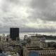 Vista aérea da cidade do Rio de Janeiro com baía, ponte e céu nublado.