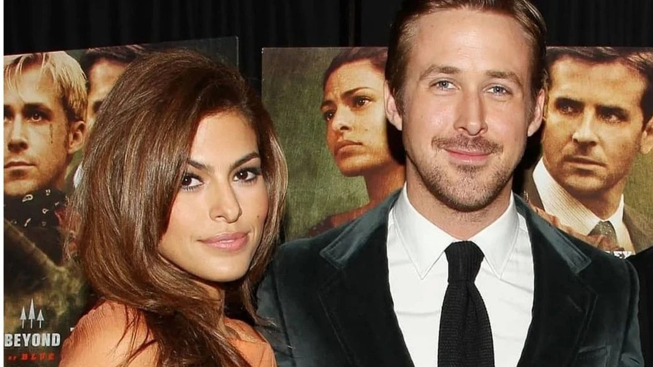 Ryan Gosling e Eva Mendes posando, sorrindo. Pôsteres de filmes em segundo plano.