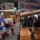 Pessoas superlotam ônibus, algumas pulando janelas, outras no teto, em rua de Copacabana