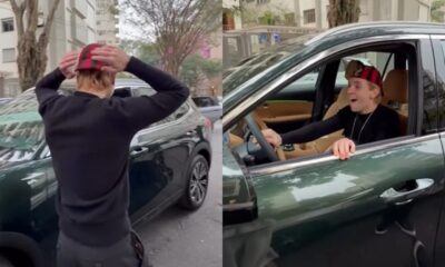 Juliano Floss, de boné xadrez, sorri de dentro de um SUV verde escuro