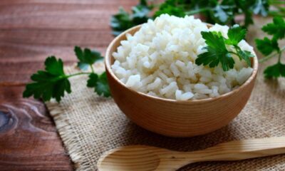 Tigela de madeira com arroz branco soltinho, salsa e colher de madeira