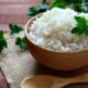 Tigela de madeira com arroz branco soltinho, salsa e colher de madeira