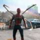 Homem-Aranha com traje vermelho e dourado, braços mecânicos, em rodovia destruída e chuvosa.