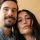 Nicolas Prattes e Sabrina Sato sorrindo em close-up, com a cabeça dela apoiada no ombro dele