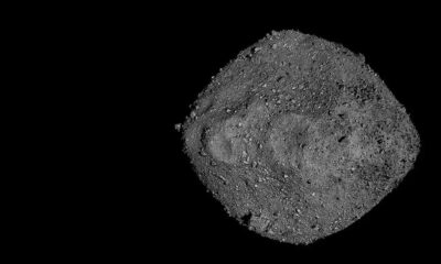 Asteroide Bennu cinza irregular com superfície rochosa e granular no espaço escuro