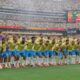 Time de futebol do Brasil posa em campo com telões exibindo 'FIFA World Cup 2026', 'Brazil' e 'Norway'.