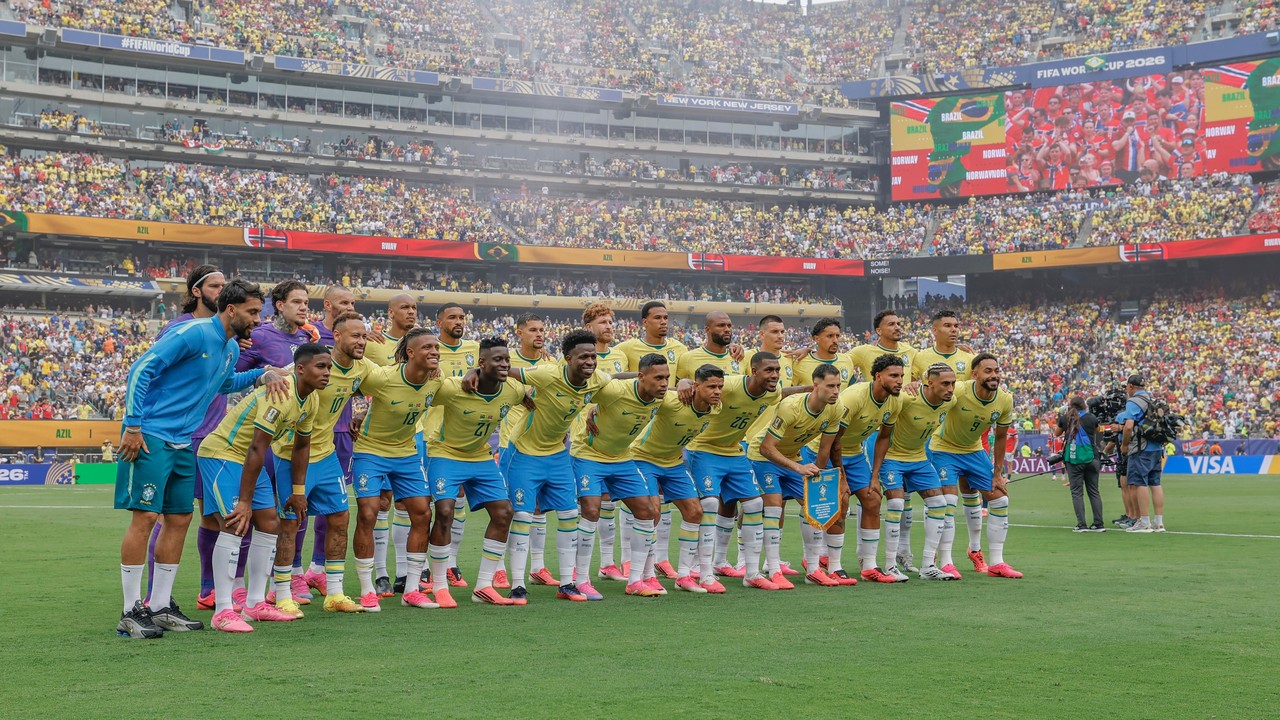 Time de futebol do Brasil posa em campo com telões exibindo 'FIFA World Cup 2026', 'Brazil' e 'Norway'.