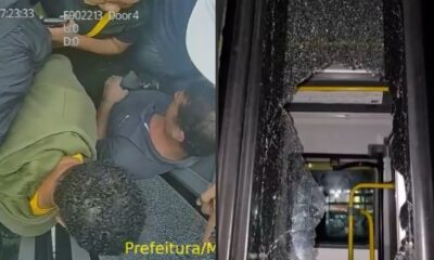 Dois homens dentro de um ônibus e uma porta de vidro do BRT estilhaçada.