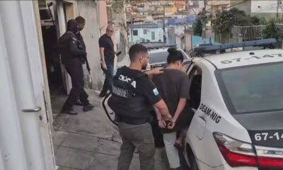 Policiais escoltam mulher algemada para viatura da DEAM-NIG em operação policial