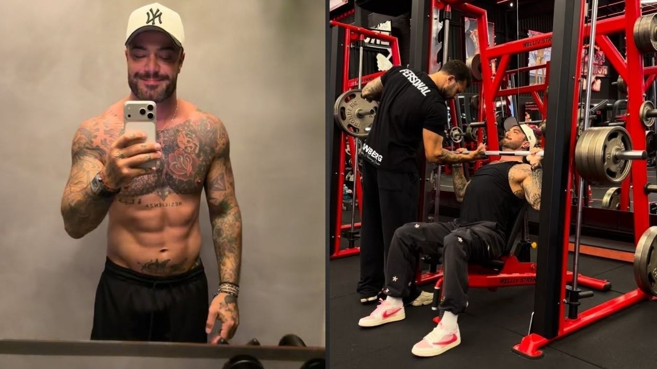 Felipe Titto, tatuado, posa para selfie e treina peitoral na academia com personal.
