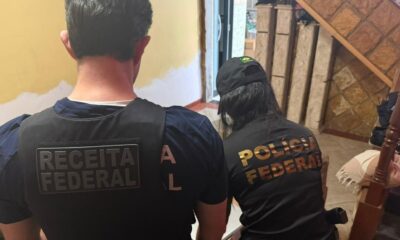 Agentes da Receita Federal e Polícia Federal, de costas, em colete e camisa identificados