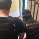 Agentes da Receita Federal e Polícia Federal, de costas, em colete e camisa identificados