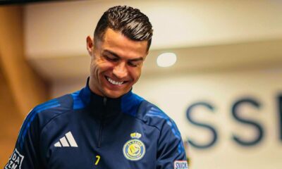 Cristiano Ronaldo sorri usando agasalho azul com o logo do Al Nassr