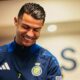 Cristiano Ronaldo sorri usando agasalho azul com o logo do Al Nassr