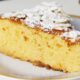 Fatia de bolo amarelo com cobertura de açúcar de confeiteiro e amêndoas laminadas em um prato