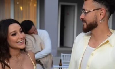 Fred Bruno e Indi sorrindo e se olhando; homem em segundo plano
