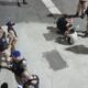 Agentes de segurança uniformizados detendo dois indivíduos na calçada à noite