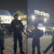 Policiais militares fardados com capacetes e fuzis em operação noturna, sob placa "CORAGEM"