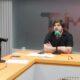 Alexandre Frota e dois apresentadores em estúdio de podcast, com microfones e mesa laranja