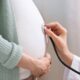 Mão de profissional com estetoscópio examinando barriga de gestante
