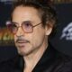 Robert Downey Jr. em close-up, usando óculos de armação laranja e roxa