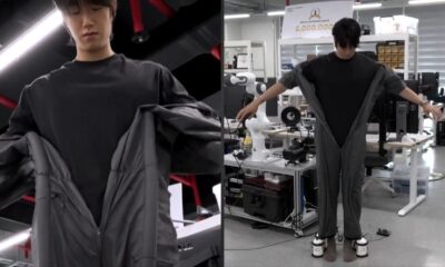 Homem em laboratório experimenta roupa robótica cinza que se veste sozinha, com dispositivos nos pés