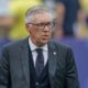 Carlo Ancelotti, de terno, colete, gravata e óculos, com cabelo grisalho