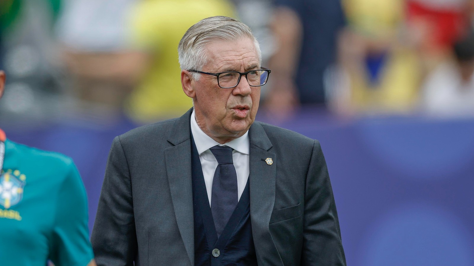 Carlo Ancelotti, de terno, colete, gravata e óculos, com cabelo grisalho