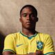 Endrick em camisa amarela da Seleção Brasileira com logotipos CBF e Nike, braços cruzados