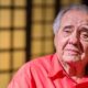 Luiz Carlos Barreto, homem idoso de cabelo grisalho e camisa vermelho-alaranjada