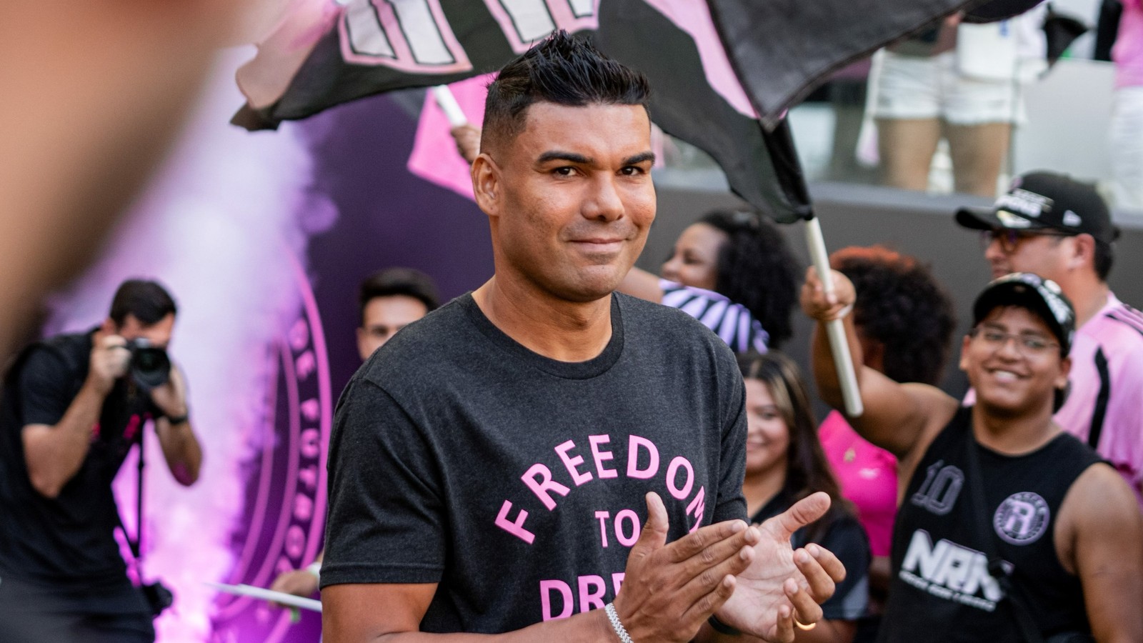 Casemiro, sorrindo e aplaudindo, com camisa "FREEDOM TO DREAM" em evento do Inter Miami