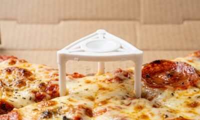 Por que toda caixa de pizza tem uma pequena peça de plástico no centro e qual é sua verdadeira função